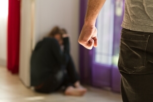 Man approaching crouching woman - Boise Domestic Violence Lawyer